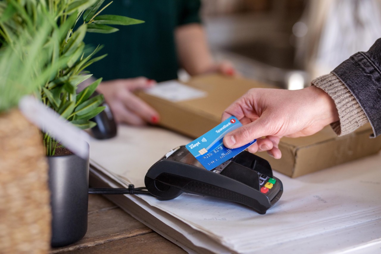 En person betaler med debetkort i en butikk. 