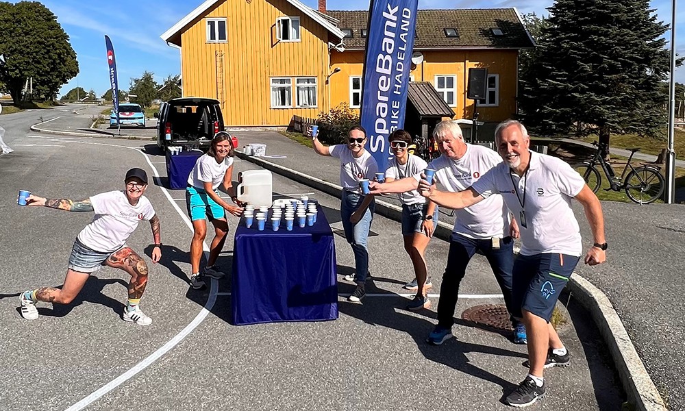 Mange ansatte står på drikkestasjon ved Røyse skole under Ringeriksmaraton 2022. 