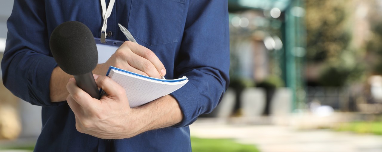 smn-toppbanner-presse-journalist-med-mikrofon-og-notatblokk