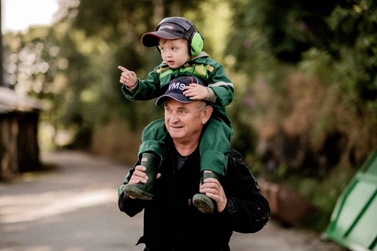 bonde med barnebarn på ryggen. foto.