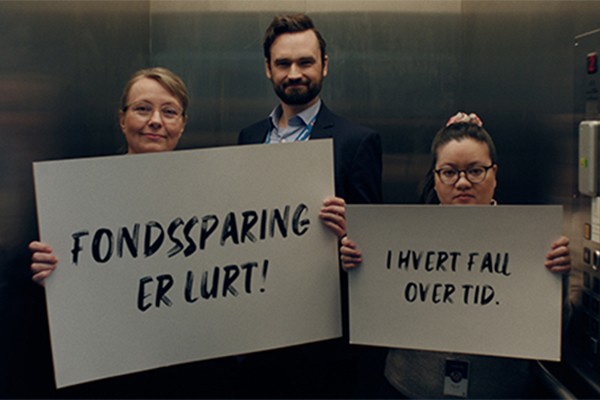 Rådgivere fra fondskampanjen holder plakater med tekst: Fondssparing er lurt! I hvert fall over tid.