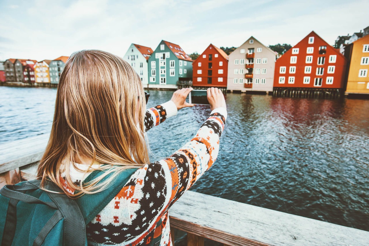 Reisende kvinne tar bilde med smarttelefon på sightseeing i Trondheim i Norge.