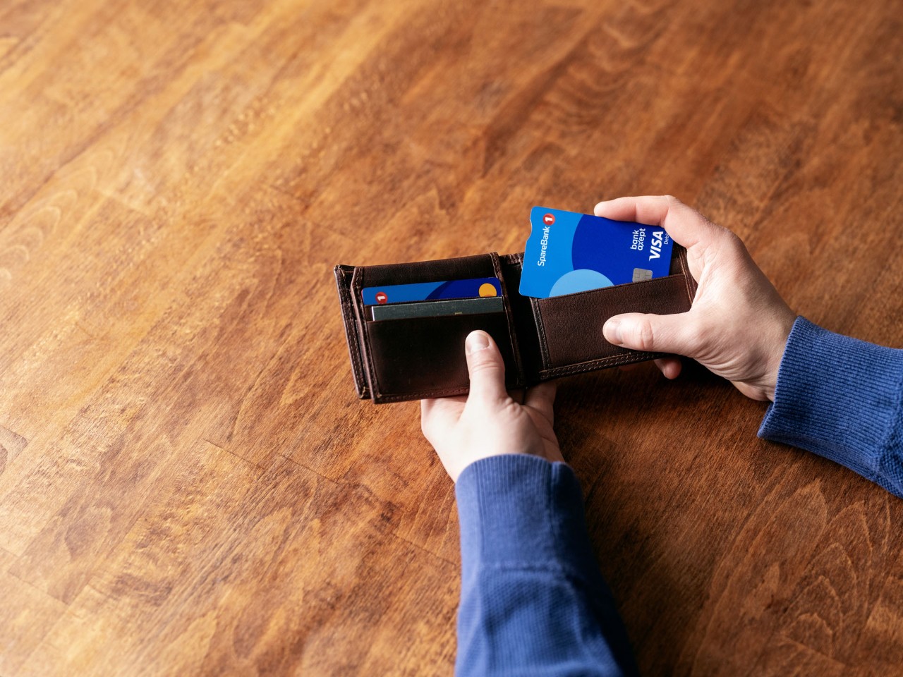 Bankkort og kredittkort på bord med kaffekopp