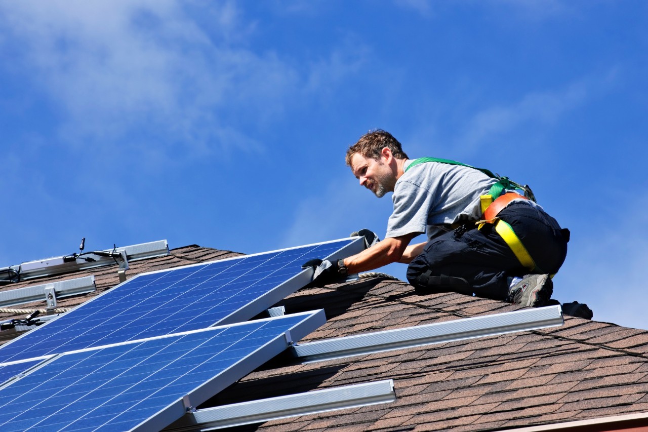 mann på tak som installerer solcelle. foto.