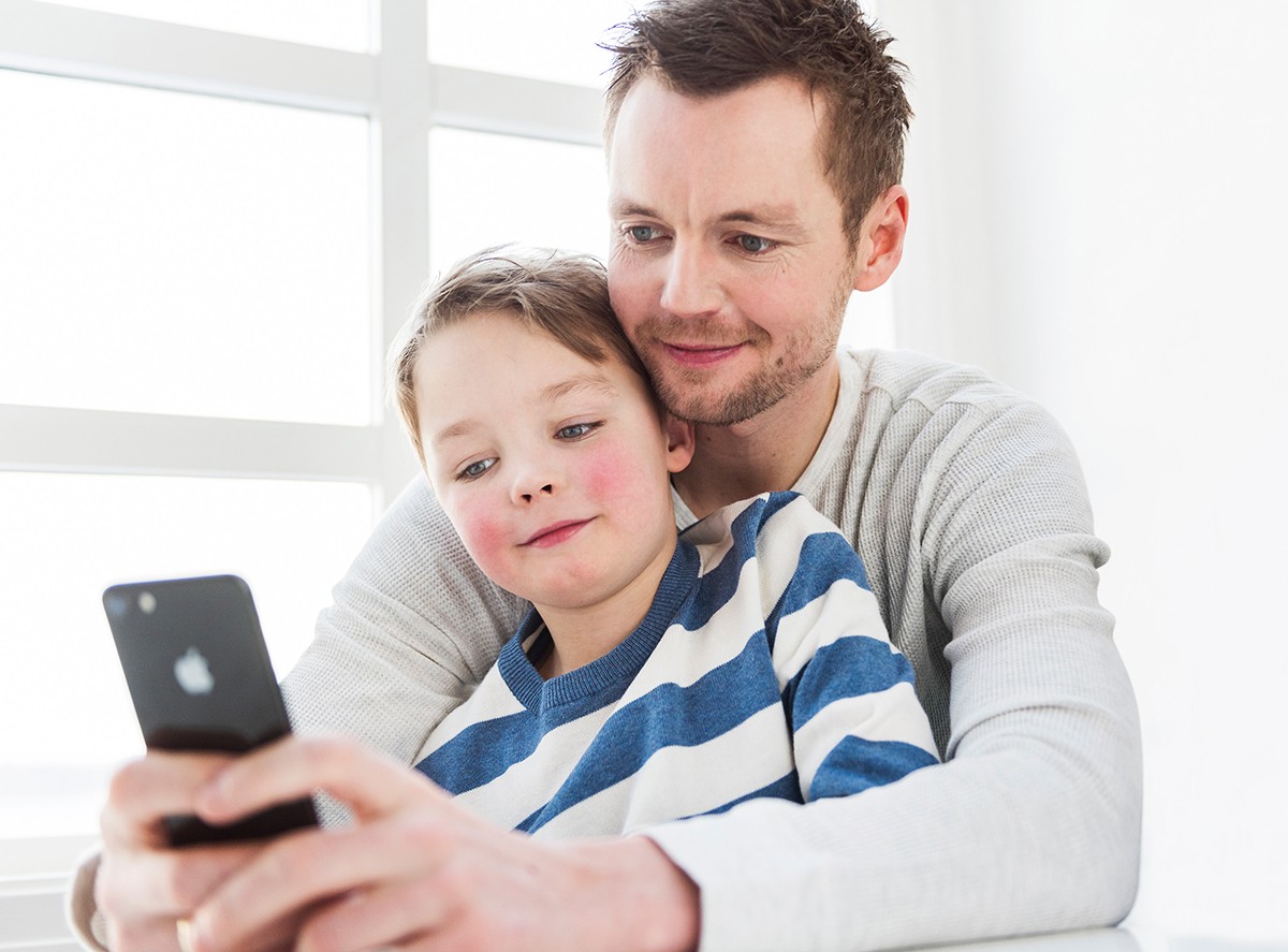 Barn og far eller mann med mobil 