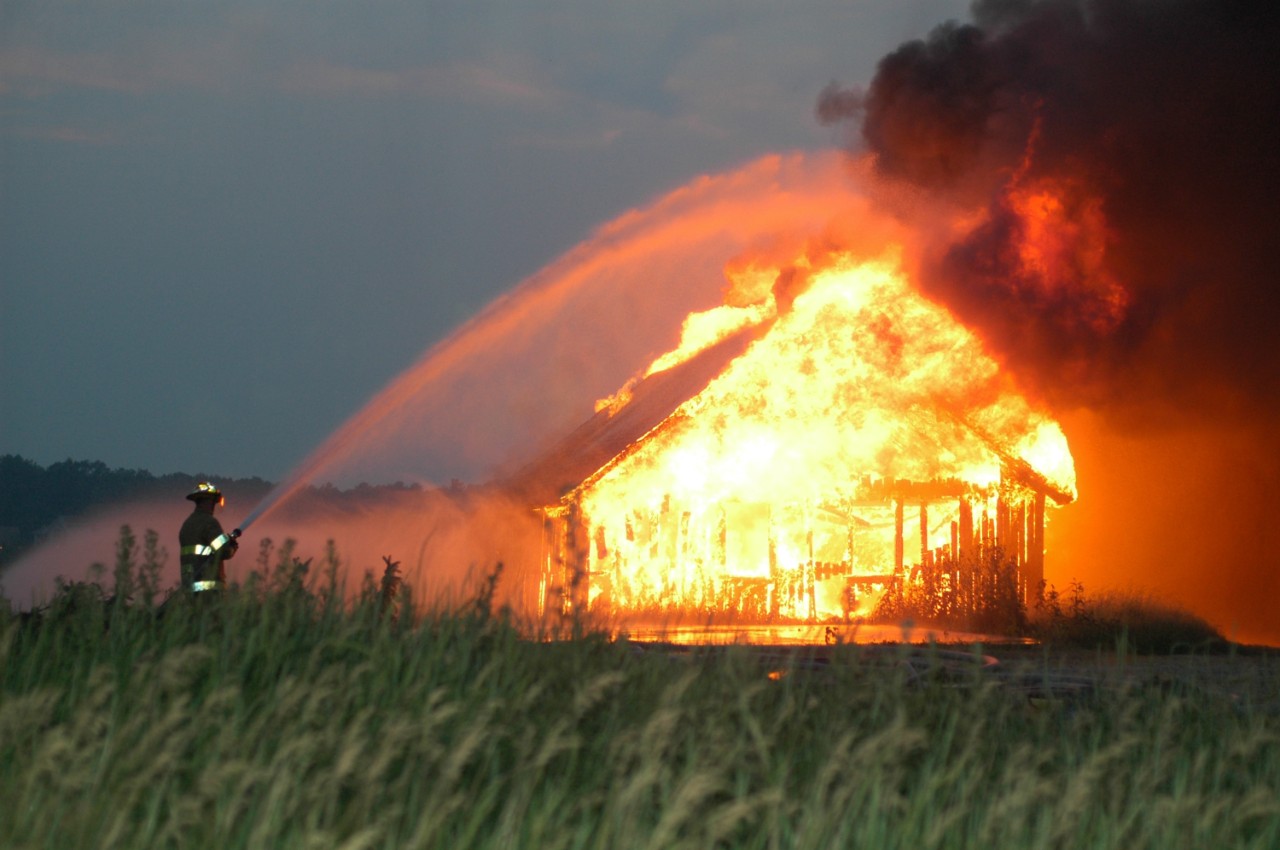 en gård brenner ned og en brannmann prøver å slukke