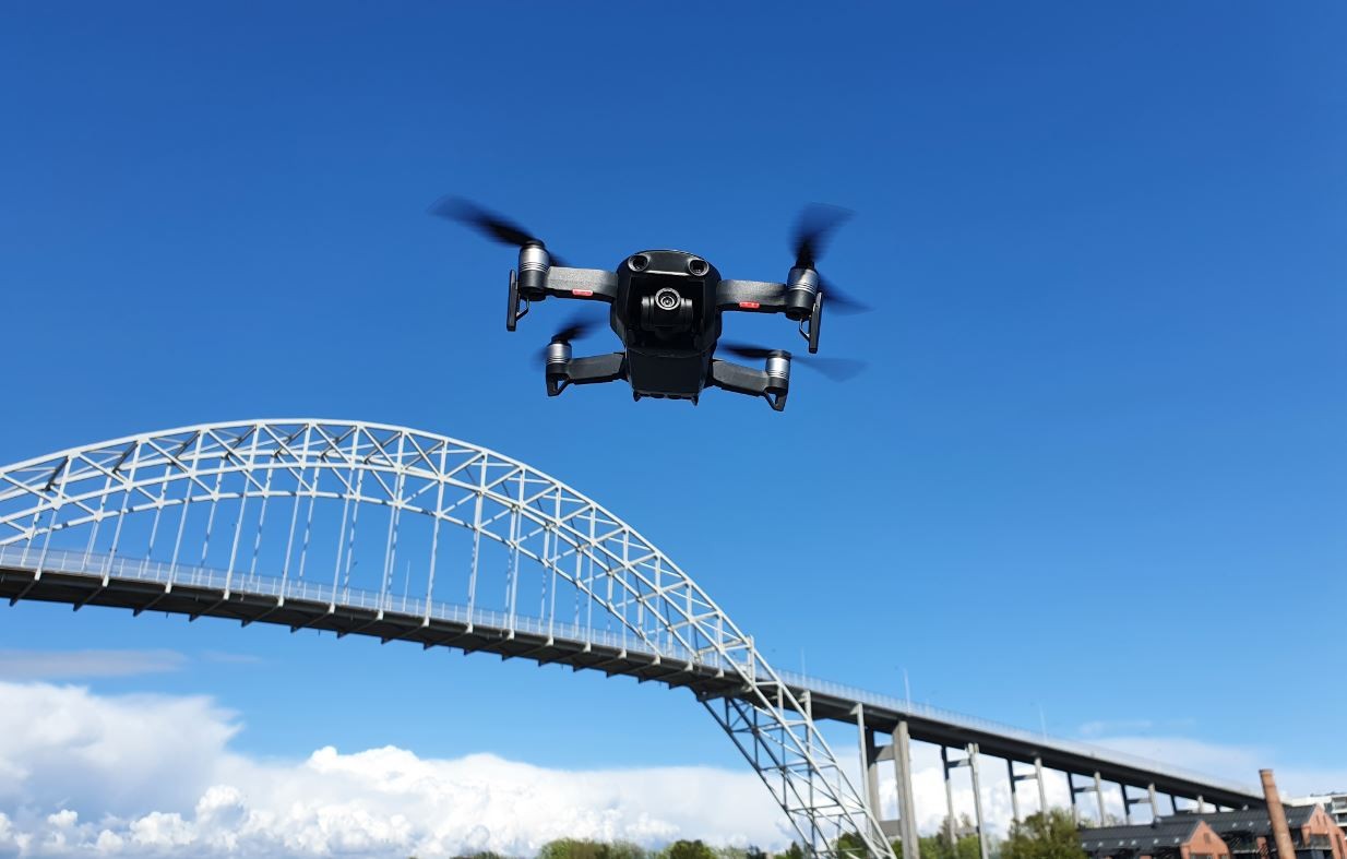 En drone med droneforsikring som flyr over en bro i Fredrikstad