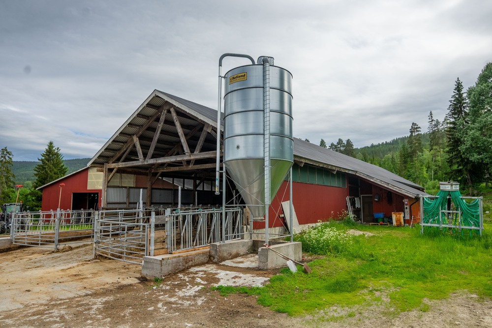 et landbruksbygg med silo, utstyr og redskaper
