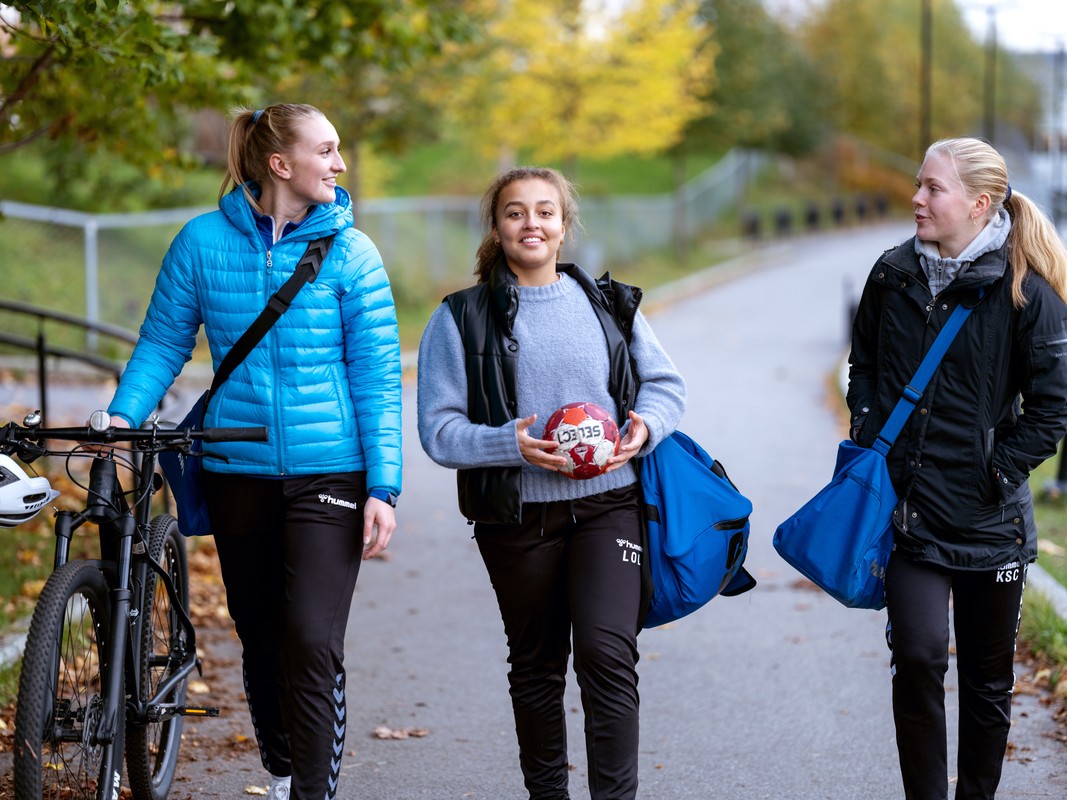 jenter med ulykkesforsikring går hjem fra håndball trening en høstdag