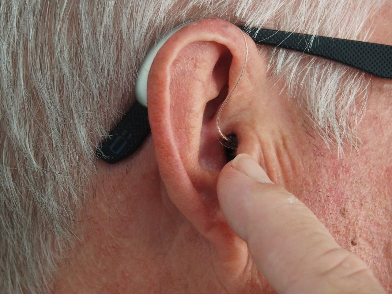 nærbilde av øret til en mann med høreapparat