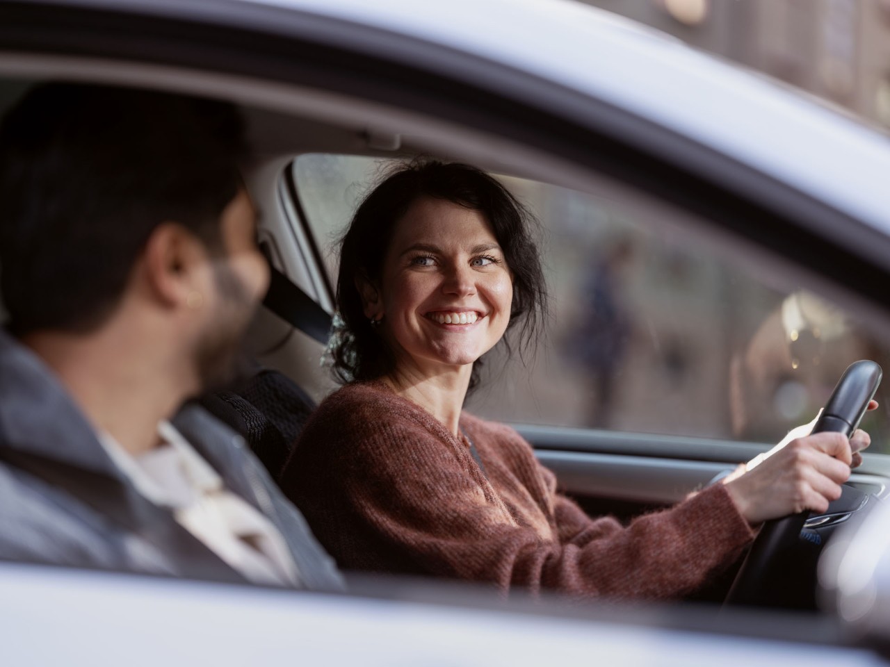Smilende par i leasing-bil med bilforsikring