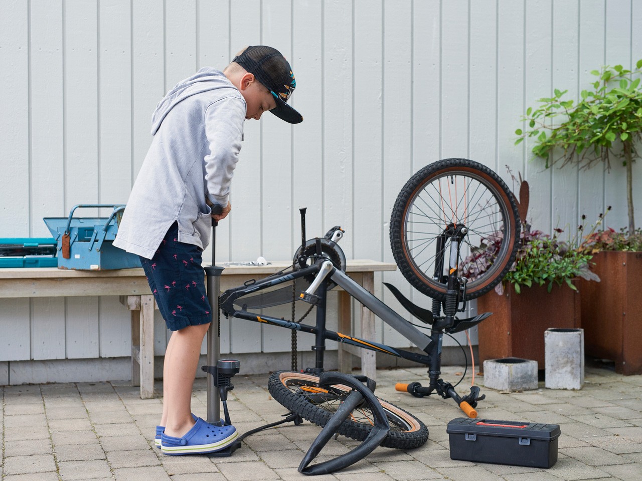gutt reparerer og pumper opp sykkeldekk på sykkelen sin