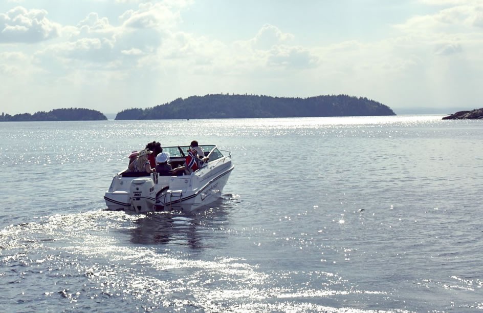 familie ute på sjøen i sola med båt som er registrert i båtregister