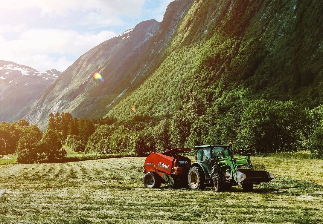 bonde kjører traktor på åker