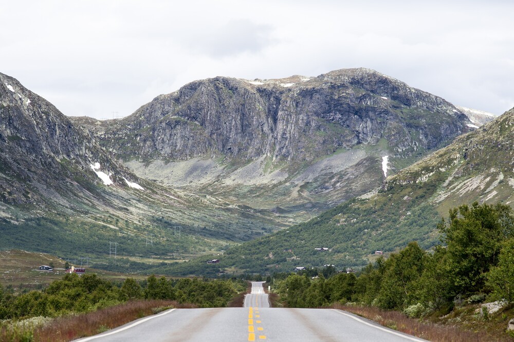 Utsikt fra en trailer utover en vei i flott fjell landskap