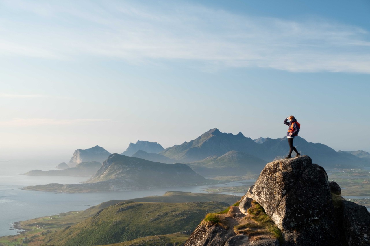 En person som står på en fjelltopp og tenker på framtid og pensjon